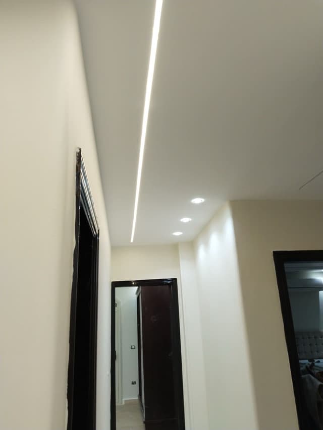 Expert gypsum board wall installation showing seamless joint work, smooth finishing, and professional taping techniques