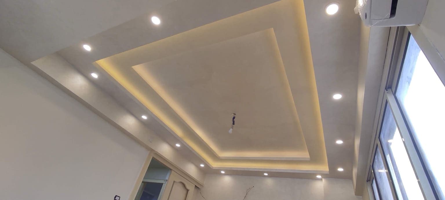 Complex multi-level gypsum board ceiling featuring step-down boxes and integrated lighting recesses