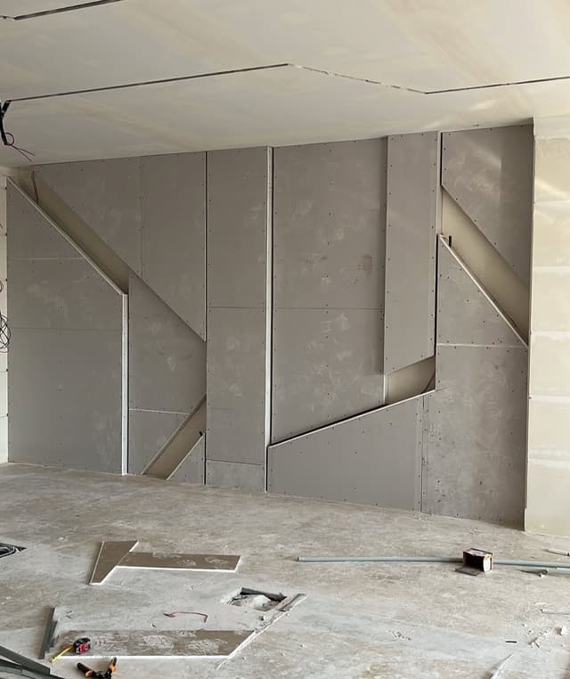 Gypsum board installation on exterior wall with proper moisture barriers and insulation